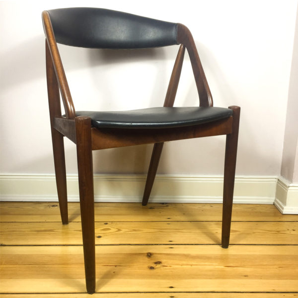 Kai Kristiansens M31 Teakholzstuhl aus den 1960er Jahren ist eine Design Liebling der Mid Century Modern Anhänger. Ein beliebter Esszimmerstuhl. Hier ein Einzelstück, das sich perfekt als Schreibtischstuhl, verwenden lässt. Die Lehne ist rundgeformt, sodaß sich er Rücken wunderbar in die Lehne legen kann. Der Bezug ist aus schwarzem Kunstleder. Original, wie es zu der Zeit verwendet wurde. Heute ist dieser Stuhl wieder ausserordentlich beliebt.