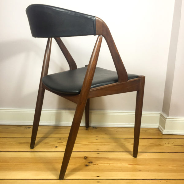Kai Kristiansens M31 Teakholzstuhl aus den 1960er Jahren ist eine Design Liebling der Mid Century Modern Anhänger. Ein beliebter Esszimmerstuhl. Hier ein Einzelstück, das sich perfekt als Schreibtischstuhl, verwenden lässt. Die Lehne ist rundgeformt, sodaß sich er Rücken wunderbar in die Lehne legen kann. Der Bezug ist aus schwarzem Kunstleder. Original, wie es zu der Zeit verwendet wurde. Heute ist dieser Stuhl wieder ausserordentlich beliebt.