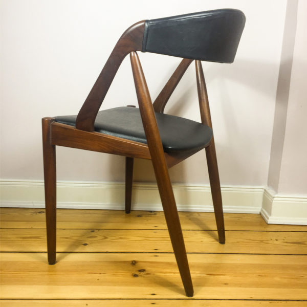 Kai Kristiansens M31 Teakholzstuhl aus den 1960er Jahren ist eine Design Liebling der Mid Century Modern Anhänger. Ein beliebter Esszimmerstuhl. Hier ein Einzelstück, das sich perfekt als Schreibtischstuhl, verwenden lässt. Die Lehne ist rundgeformt, sodaß sich er Rücken wunderbar in die Lehne legen kann. Der Bezug ist aus schwarzem Kunstleder. Original, wie es zu der Zeit verwendet wurde. Heute ist dieser Stuhl wieder ausserordentlich beliebt.