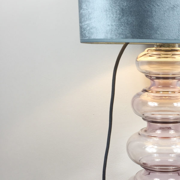 Eine sehr schöne Lampe mit einem Glaskorpus aus leicht rosé getöntem Glas. Trotz ihrer Größe vermittelt die Lampe Leichtigkeit. Der Schirm ist aus taupe-farbenem Samt. Der Korpus besteht aus 6 Glasringe, oder Ausbuchtungen, die sich von unten nach oben verjüngen, also schmaler werden.