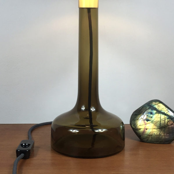 Tischlampe Glas Braun. Flacher, breiter Fuss mit langem Hals mit einer Messingmontur für die Fassung. Darauf ist der Lampenschirm befestigt. Dieser ist mit einem geometrischen Art Deco Design in Altrosa bespannt.