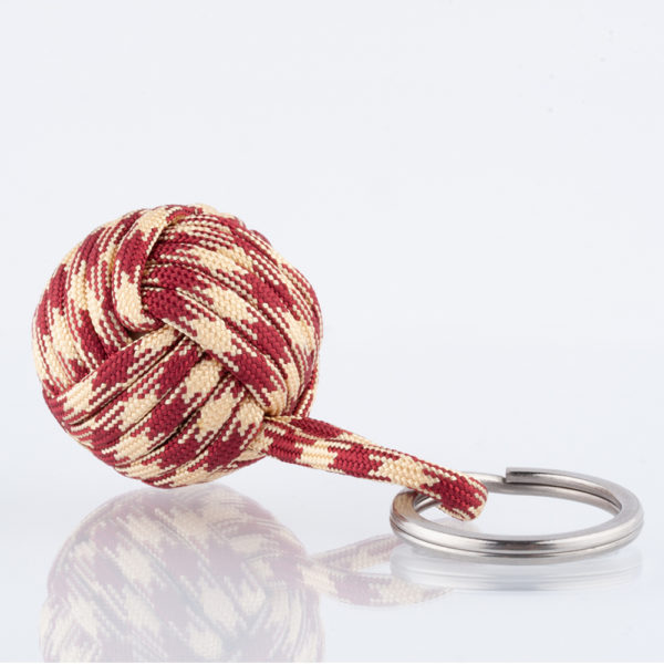 Der Seglerknoten Affenfaust als Schlüsselanhänger aus Paracord im Hahnentritt Design. Hier in Weinrot und Cremefarben in einer Größe von 3,7cm. Der Anhänger ist mit einem Edelstahlfederring in 32mm Durchmesser für die Schlüssel versehen. Der Anhänger ist handgefertigt in hochwertiger Verarbeitung. Der kleine Helfer für den Alltag. Für Männer als auch für Frauen, die den angesagten Stil mit dem Hahnentritt Muster lieben. Maritim durch den Seglerknoten und doch gleichzeitig im Trend durch das Hahnentrittdesign.