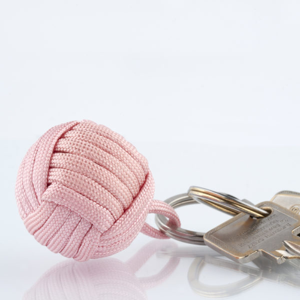 Seglerknoten Affenfaust. Ein Schlüsselanhänger aus rosafarbenem Paracordseil. Ein DIY Produkt. Der Schlüsselanhänger ist mit einem 3,2cm großen Edestahlfederring versehen.