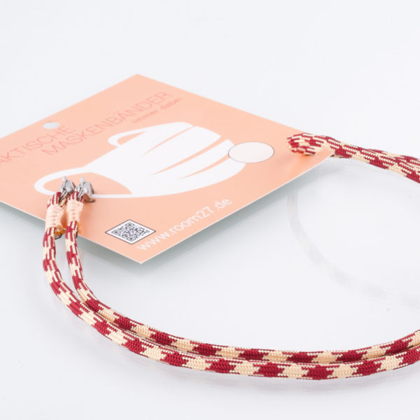 Das Masken Band ist der kleine Helfer im Alltag. Hier in der Farbkombi bordeaux und creme im Hahnentrittmuster. Damit Du nicht ständig Deine Maske aus der Tasche holen musst, oder in der Hand hältst, hängst Du die Maske mit dem Band einfach um den Hals und steckst sie Dir in die Tasche Deines Oberhemdes, oder in die Revertasche Deiner Jacke, wenn Du sie nicht benötigst. Sie kann aber auch einfach runterhängen. Ob Du bei der Arbeit bist, in ein Geschäft, oder ins Restaurant gehst, Du kannst sie schnell aufsetzen. Sogar mit einer Hand ist das möglich. Die zwei Karabinerverschlüsse klemmst Du einfach an das Gummiband, das bei Gebrauch um die Ohren gelegt wird. Durch das Eigengewicht hängen die Karabiner an der tiefsten Stelle des Gummibandes, sodaß sie auch nicht an den Ohren drücken können. Die Maskenbänder werden mit Deinem Farb-Wunsch angefertigt. Wähle Deine Wunschfarbe für die Bänder, die die Karabiner halten, im Menü aus.