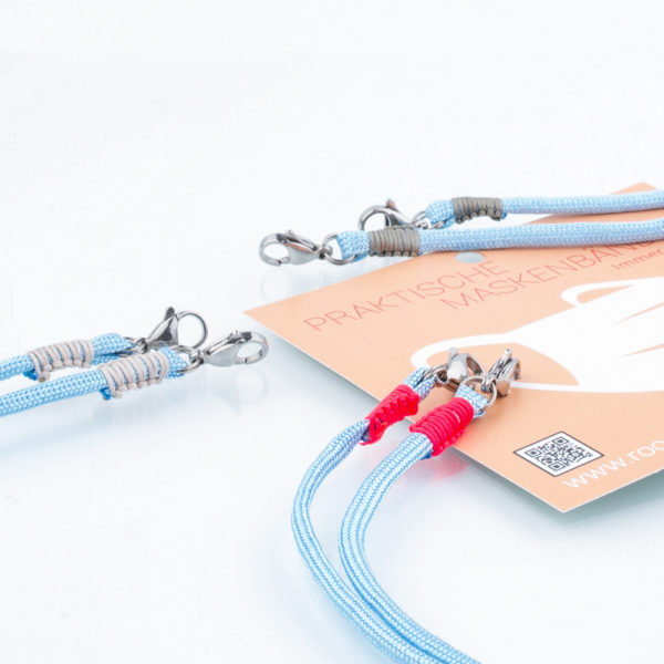 Das Maskenband ist der kleine Helfer im Alltag. Hier in der Farbkombi in hellblau und neonpink. Hellblau ist eine freundliche und leichte Farbe. Sie passt sehr gut zu einer weissen Bluse, oder einem weissen Hemd. Damit Du nicht ständig Deine Maske aus der Tasche holen musst, oder in der Hand hältst, hängst Du die Maske mit dem Band einfach um den Hals und steckst sie Dir in die Tasche Deines Oberhemdes, oder in die Revertasche Deiner Jacke, wenn Du sie nicht benötigst. Sie kann aber auch einfach runterhängen. Ob Du bei der Arbeit bist, oder in ein Geschäft, oder ins Restaurant gehst, kannst Du sie schnell aufsetzen. Die zwei Karabinerverschlüsse klemmst Du einfach an das Gummiband, das bei Gebrauch um die Ohren gelegt wird. Durch das Eigengewicht hängen die Karabiner an der tiefsten Stelle des Gummibandes, sodaß sie auch nicht an den Ohren drücken können. Stelle Dir Deine Farbkombi zusammen.