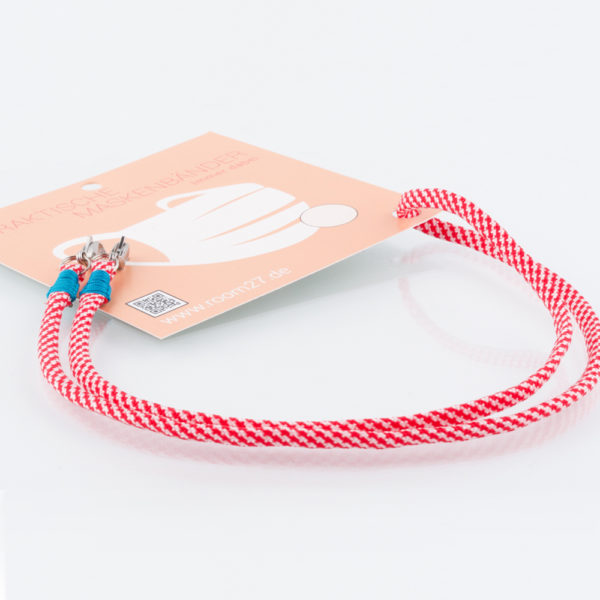 Das Masken Band ist der kleine Helfer im Alltag. Hier in der Farbkombi rot und weiss. Damit Du nicht ständig Deine Maske aus der Tasche holen musst, oder in der Hand hältst, hängst Du die Maske mit dem Band einfach um den Hals und steckst sie Dir in die Tasche Deines Oberhemdes, oder in die Revertasche Deiner Jacke, wenn Du sie nicht benötigst. Sie kann aber auch einfach runterhängen. Ob Du bei der Arbeit bist, oder in ein Geschäft, oder ins Restaurant gehst, kannst Du sie schnell aufsetzen. Die zwei Karabinerverschlüsse klemmst Du einfach an das Gummiband, das bei Gebrauch um die Ohren gelegt wird. Durch das Eigengewicht hängen die Karabiner an der tiefsten Stelle des Gummibandes, sodaß sie auch nicht an den Ohren drücken können. Wähle Deine Farbkombi für die Bänder, die den Karabiner halten.