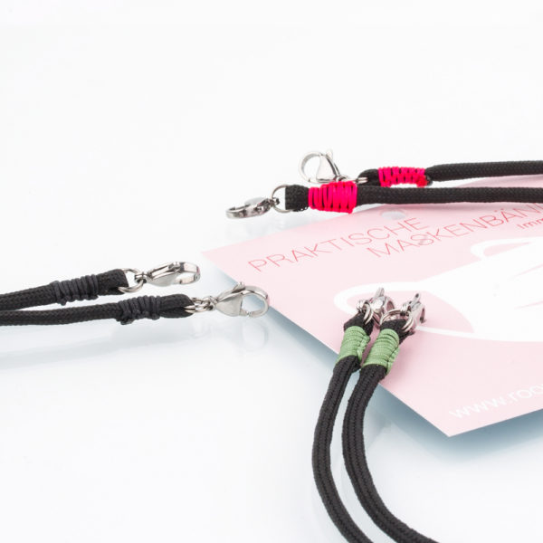 Das Maskenband ist der kleine Helfer im Alltag. Hier in der Farbkombi in schwarz und Pistazie. Schwarz ist stets elegant. Damit Du nicht ständig Deine Maske aus der Tasche holen musst, oder in der Hand hältst, hängst Du die Maske mit dem Band einfach um den Hals und steckst sie Dir in die Tasche Deines Oberhemdes, oder in die Revertasche Deiner Jacke, wenn Du sie nicht benötigst. Sie kann aber auch einfach runterhängen. Ob Du bei der Arbeit bist, oder in ein Geschäft, oder ins Restaurant gehst, kannst Du sie schnell aufsetzen. Die zwei Karabinerverschlüsse klemmst Du einfach an das Gummiband, das bei Gebrauch um die Ohren gelegt wird. Durch das Eigengewicht hängen die Karabiner an der tiefsten Stelle des Gummibandes, sodaß sie auch nicht an den Ohren drücken können. Stelle Dir Deine Farbkombi zusammen.