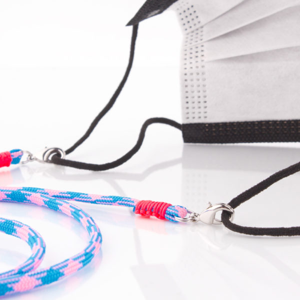 Das Maskenband ist der kleine Helfer im Alltag. Hier in der Farbkombi in Neon Blau Pink. Neon ist für den Sommer immer perfekt. Sie passt sehr gut zu einer weissen Bluse, oder einem weissen Hemd. Damit Du nicht ständig Deine Maske aus der Tasche holen musst, oder in der Hand hältst, hängst Du die Maske mit dem Band einfach um den Hals und steckst sie Dir in die Tasche Deines Oberhemdes, oder in die Revertasche Deiner Jacke, wenn Du sie nicht benötigst. Sie kann aber auch einfach runterhängen. Ob Du bei der Arbeit bist, oder in ein Geschäft, oder ins Restaurant gehst, kannst Du sie schnell aufsetzen. Die zwei Karabinerverschlüsse klemmst Du einfach an das Gummiband, das bei Gebrauch um die Ohren gelegt wird. Durch das Eigengewicht hängen die Karabiner an der tiefsten Stelle des Gummibandes, sodaß sie auch nicht an den Ohren drücken können. Die Karabiner sind mit feinen Nylonbänder befestigt. Die Farben dieser Bänder kannst Du Dir über die Tabelle aussuchen. Die Maskenbänder werden dann darauf hin gefertigt. Stelle Dir Deine Farbkombi zusammen.