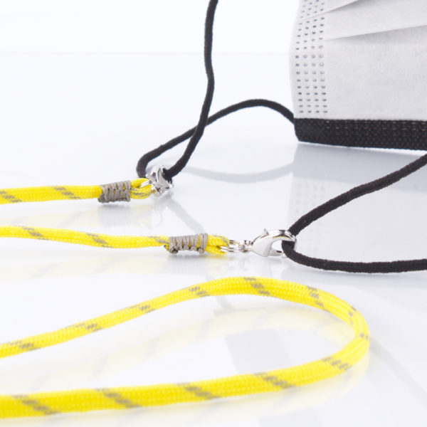 Das Maskenband ist der kleine Helfer im Alltag. Hier in der Farbkombi in Neon Gelb Grau. Neon ist für den Sommer immer perfekt. Sie passt sehr gut zu einer weissen Bluse, oder einem weissen Hemd. Damit Du nicht ständig Deine Maske aus der Tasche holen musst, oder in der Hand hältst, hängst Du die Maske mit dem Band einfach um den Hals und steckst sie Dir in die Tasche Deines Oberhemdes, oder in die Revertasche Deiner Jacke, wenn Du sie nicht benötigst. Sie kann aber auch einfach runterhängen. Ob Du bei der Arbeit bist, oder in ein Geschäft, oder ins Restaurant gehst, kannst Du sie schnell aufsetzen. Die zwei Karabinerverschlüsse klemmst Du einfach an das Gummiband, das bei Gebrauch um die Ohren gelegt wird. Durch das Eigengewicht hängen die Karabiner an der tiefsten Stelle des Gummibandes, sodaß sie auch nicht an den Ohren drücken können. Die Karabiner sind mit feinen Nylonbänder befestigt. Stelle Dir Deine Farbkombi zusammen.