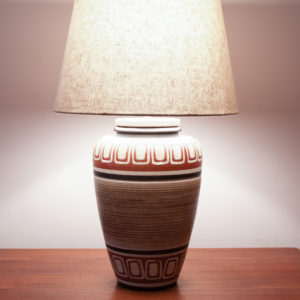 BUENOS DIAS. Das Design der Lampe ist im mexican Style der 50er Jahre. Warme Farben und geometrische Muster kommen hier zusammen. Ein Traumteil! Die erdverbundenen Farben erinnern auch an das INKA-Volk mit Ihren Höhlenmalereien. Die Farbtöne bewegen sich zwischen Sand, Weinrot, Schwarz, und einem erdigen Braun. Das geometrische Muster ist in den getöpferten Korpus eingeritzt.