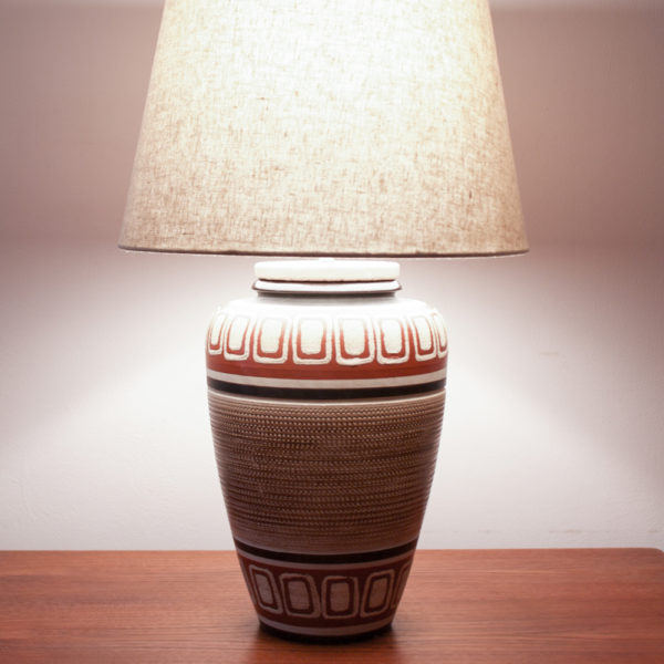 BUENOS DIAS. Das Design der Lampe ist im mexican Style der 50er Jahre. Warme Farben und geometrische Muster kommen hier zusammen. Ein Traumteil! Die erdverbundenen Farben erinnern auch an das INKA-Volk mit Ihren Höhlenmalereien. Die Farbtöne bewegen sich zwischen Sand, Weinrot, Schwarz, und einem erdigen Braun. Das geometrische Muster ist in den getöpferten Korpus eingeritzt.