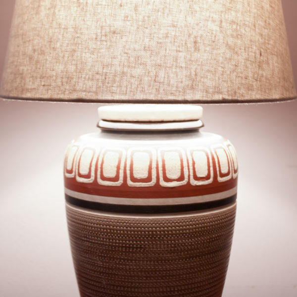 BUENOS DIAS. Das Design der Lampe ist im mexican Style der 50er Jahre. Warme Farben und geometrische Muster kommen hier zusammen. Ein Traumteil! Die erdverbundenen Farben erinnern auch an das INKA-Volk mit Ihren Höhlenmalereien. Die Farbtöne bewegen sich zwischen Sand, Weinrot, Schwarz, und einem erdigen Braun. Das geometrische Muster ist in den getöpferten Korpus eingeritzt.