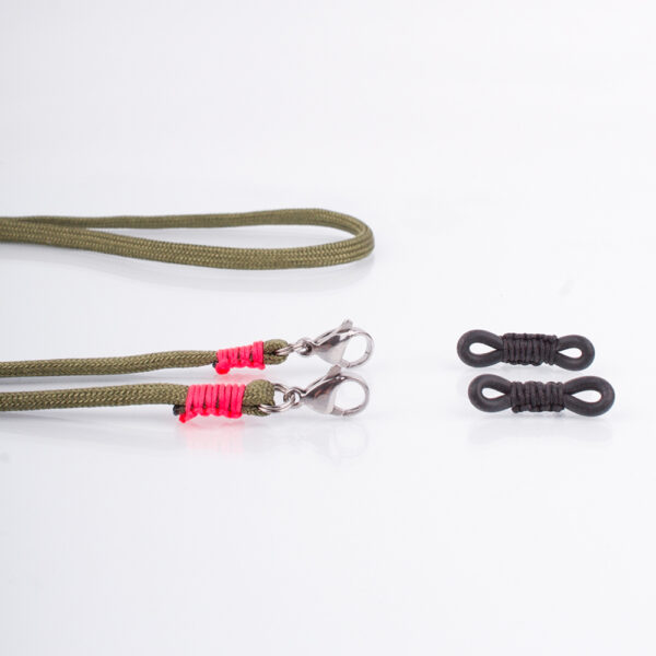 Brillenband Paracord Oliv. Der Olivton ist eine Trendfarbe. Ein Dauerbrenner. Die Farbe kann zum Casual Look als auch zum klassischen Outfit getragen werden. Zu Oliv passen im Kontrast zum Beispiel alle Jeanstöne, aber auch alle anderen Farben kannst Du zu diesem Ton tragen. Ein klassisches Dunkelblau mit einem modernem Look, oder auch zum Anzug. Ganz egal. Auch knallige Farben passen zu diesem Brillenband. Das ist das tolle an diesem Brillenband. Das Brillenband ist sehr hochwertig verarbeitet und ist auf Langlebigkeit ausgerichtet. Die Karabiner sind mit 1,0 mm Nylonband fixiert. Das Nylon Band kannst Du Dir mittels des Menüs auswählen und dann wird Dein individuelles Band handgefertigt. Damit Du nicht ständig Deine Brille aus der Tasche holen musst, oder irgendwo ablegst und sie nicht wiederfindest, hängst Du sie einfach mittels der Gummischlaufen aus Naturkautschuk um den Hals. Wahlweise kannst Du die Kette auch nur mit den Karabiner nutzen, indem Du die Gummischlaufen aus den Karabinern löst und einfach die Bänder von Deiner Maske an die Karabiner klemmst. Somit hast Du eine Maskenkette, die Du auch ganz hilfreich nutzen kannst.