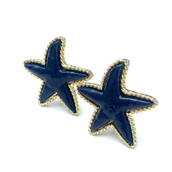 Das sind mal Statement Clips aus den 1980er Jahren! Die Sterne sind aus blauem Kunststoff und die goldene Umrandung ist aus Metall gefertigt. Dazu mit einem schlicht, klassisch geschnittenen, aber auch in einem bunt gemusterten Kleid siehst Du einfach nur schön aus. Die Ohrclips sind leicht und sind mit einem Gummistopper versehen, sodass die Clips sicher am Ohr sitzen. Diese Ohrclips sind nur ein Mal verfügbar. Den Silikonstopper legen wir beim Kauf mit bei.